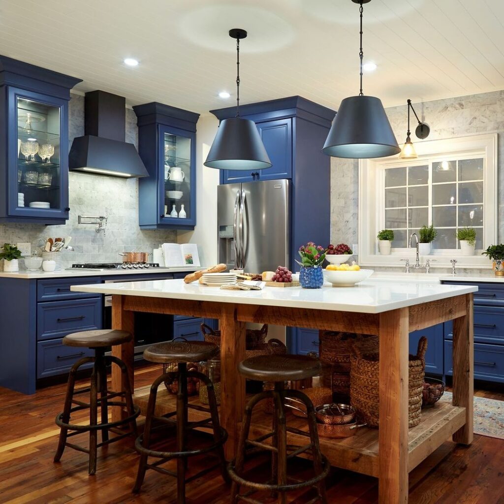 Blue kitchen cabinets, wooden floors, and center island in modern kitchen.