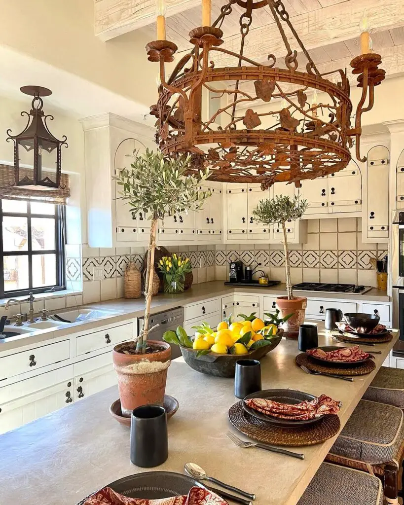 A kitchen with a grand chandelier illuminating a table.