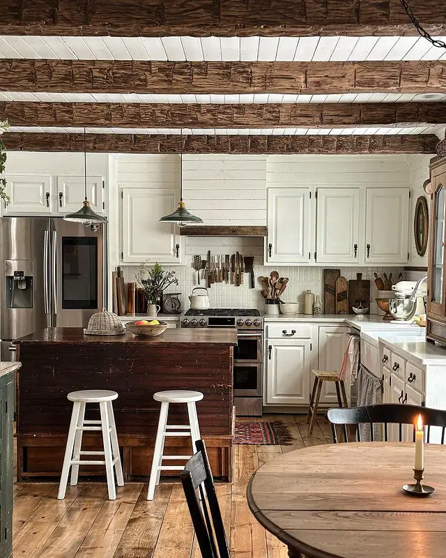 A cozy kitchen with wooden beams and a table