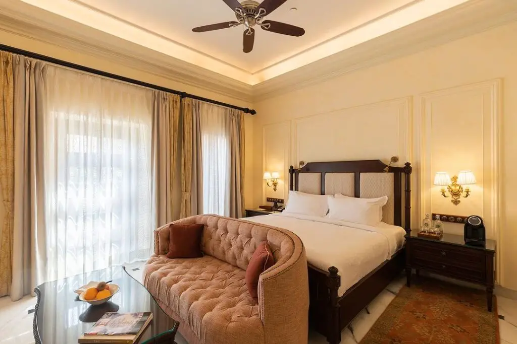 Elegant beige bedroom with peach tufted sofa