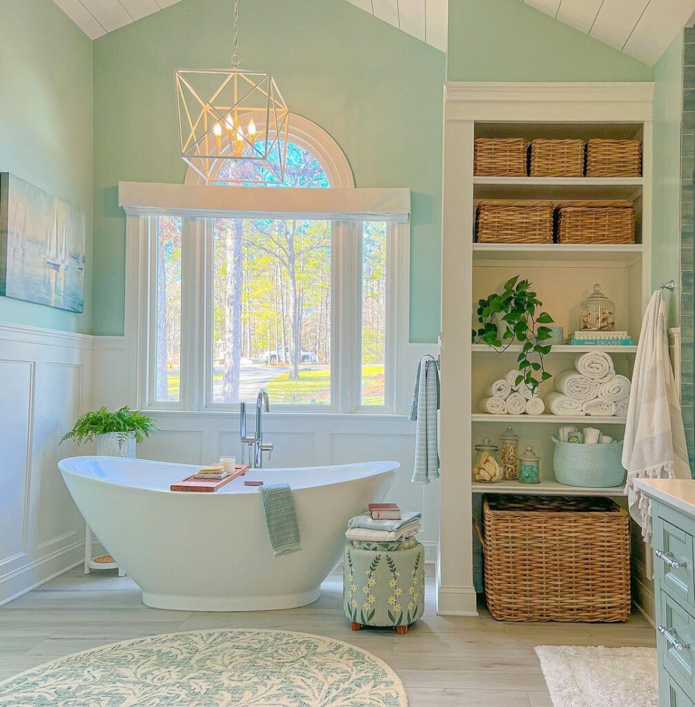 Green bathroom with freestanding tub and nature view