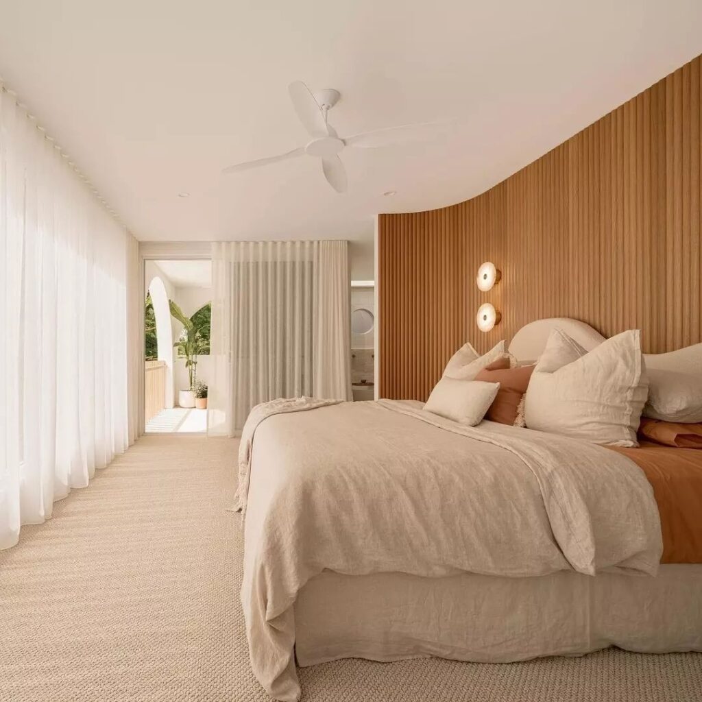 Tranquil bedroom with curved wood accent wall and neutral tones