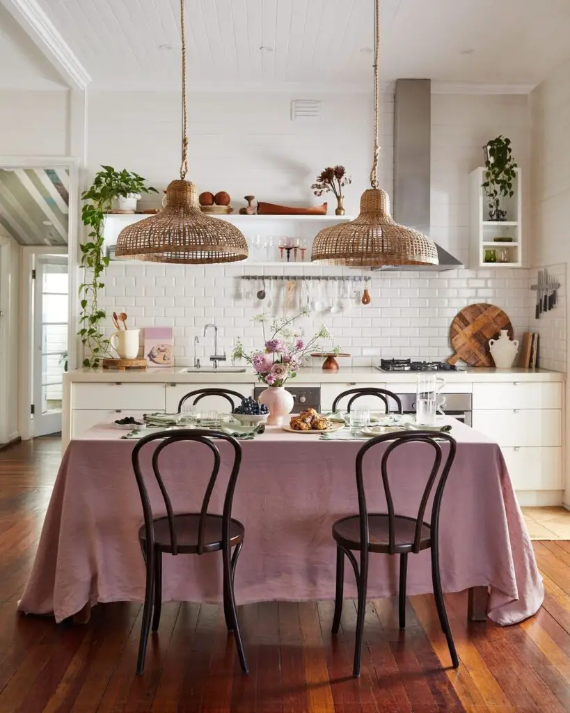 Bright kitchen with woven pendant lights pink tablecloth and white tiles