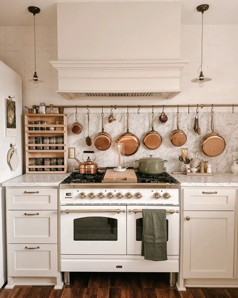 White kitchen with vintage stove copper cookware and marble backsplash