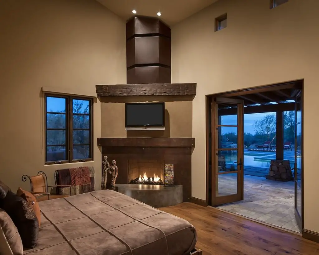 Bedroom with corner fireplace and door to pool area