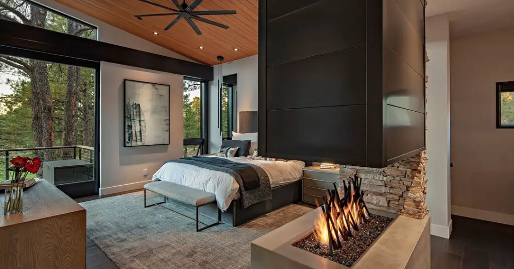 Luxurious bedroom with forest views and indoor firepit